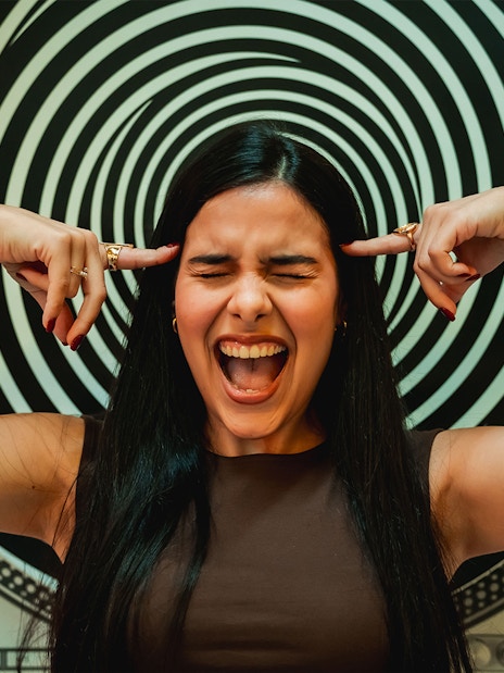 Visitor interacting with optical illusion exhibit at the Museum of Illusions, Madrid.