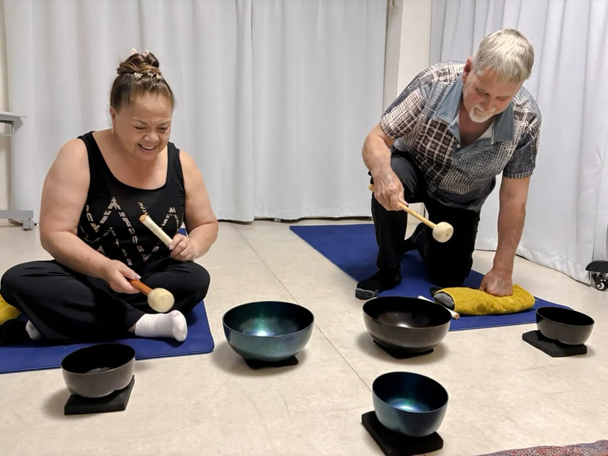 Participants using singing bowls during a private sound bath session in Kyoto.