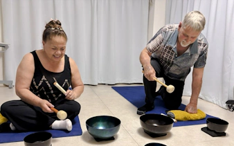 Participants using singing bowls during a private sound bath session in Kyoto.