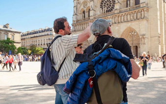 Tour guide pointing at Notre-Dame Cathedral on Île de la Cité, Paris.