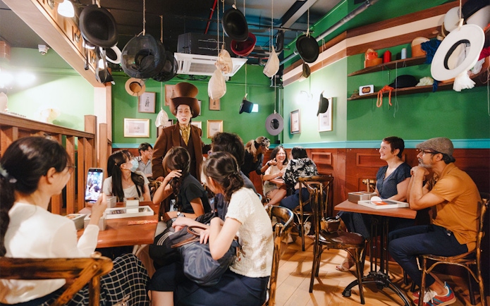 Guests enjoy an interactive tea party with the Mad Hatter at Wonderland Upside Down.
