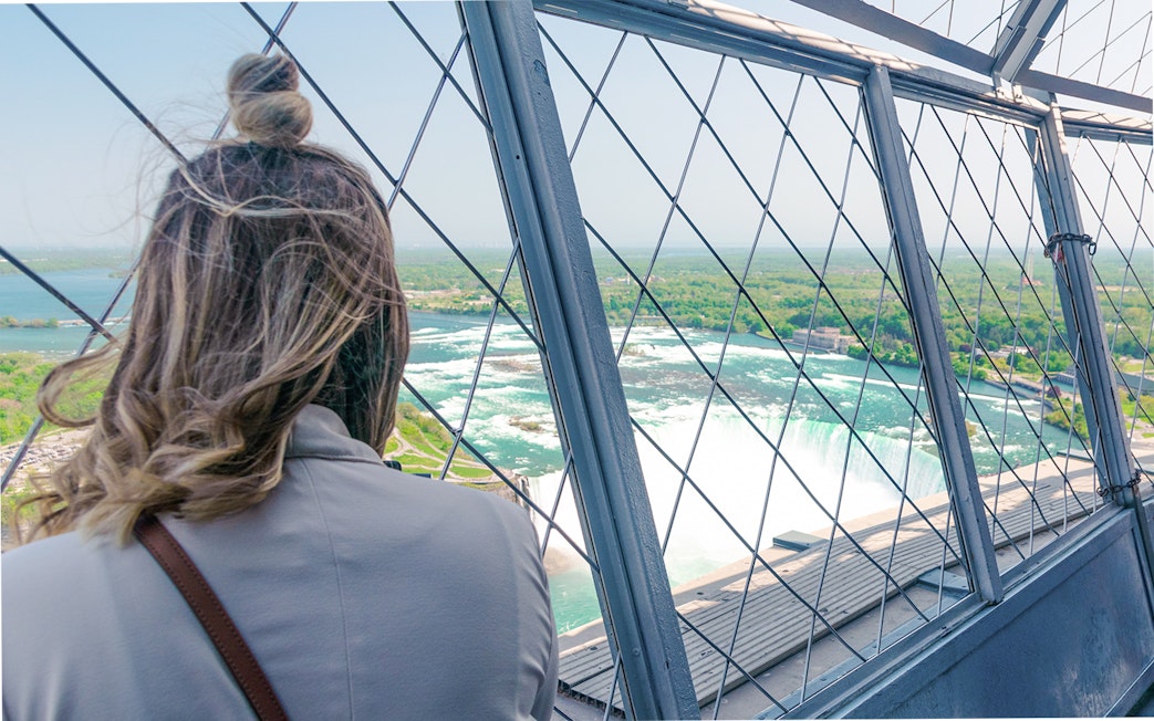 Woman viewing Niagara Falls from Skylon Tower observatory.