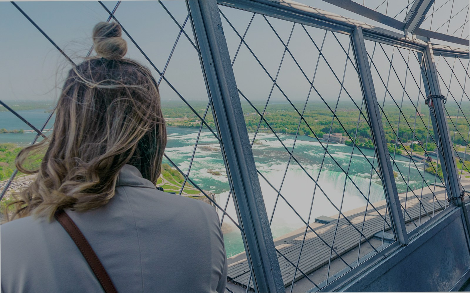 Woman viewing Niagara Falls from Skylon Tower observatory.