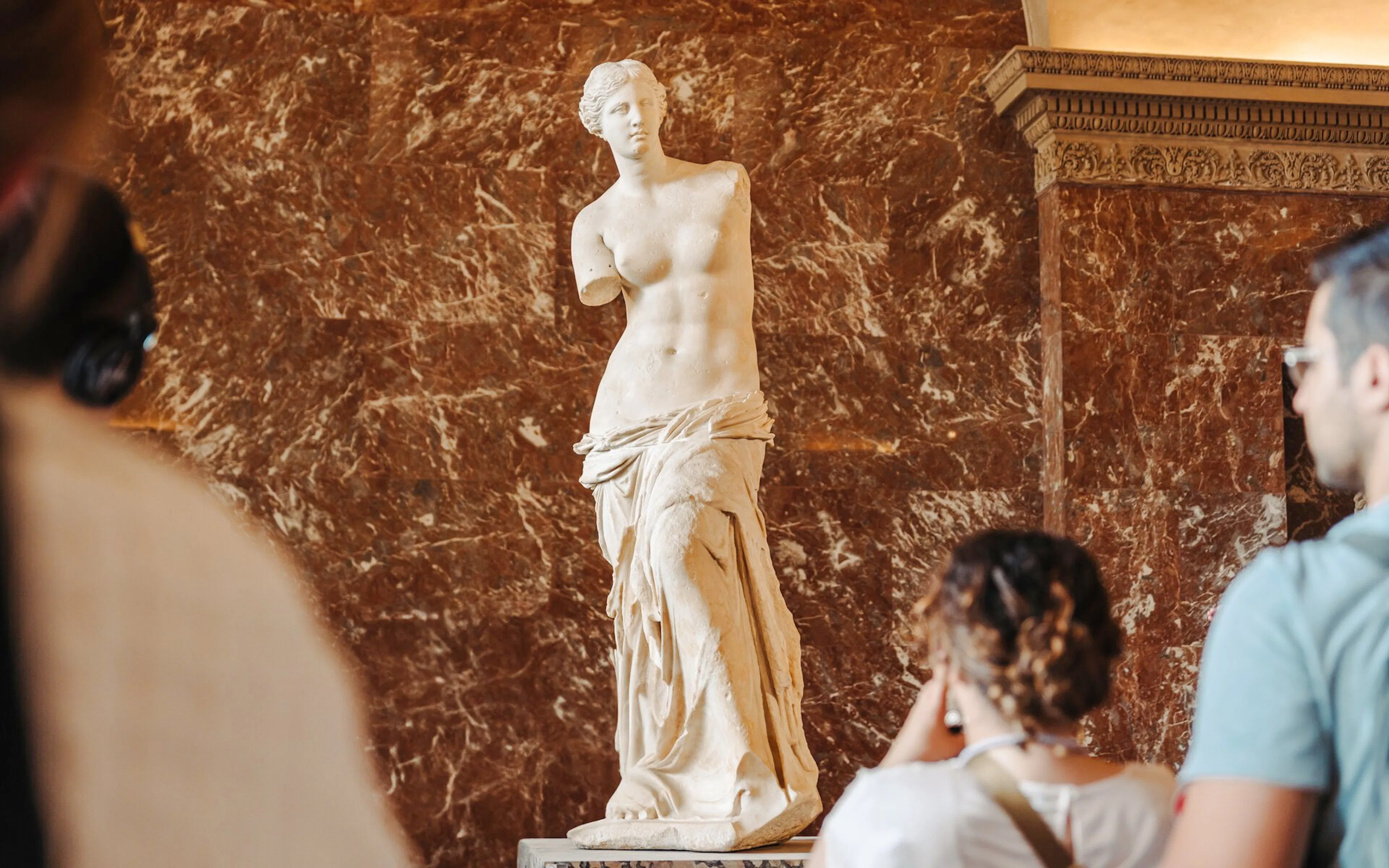 Tourists viewing the Venus de Milo statue at the Louvre Museum, Paris, France.