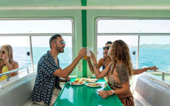 Tourists enjoying lunch on Ibiza to Formentera cruise with ocean view.
