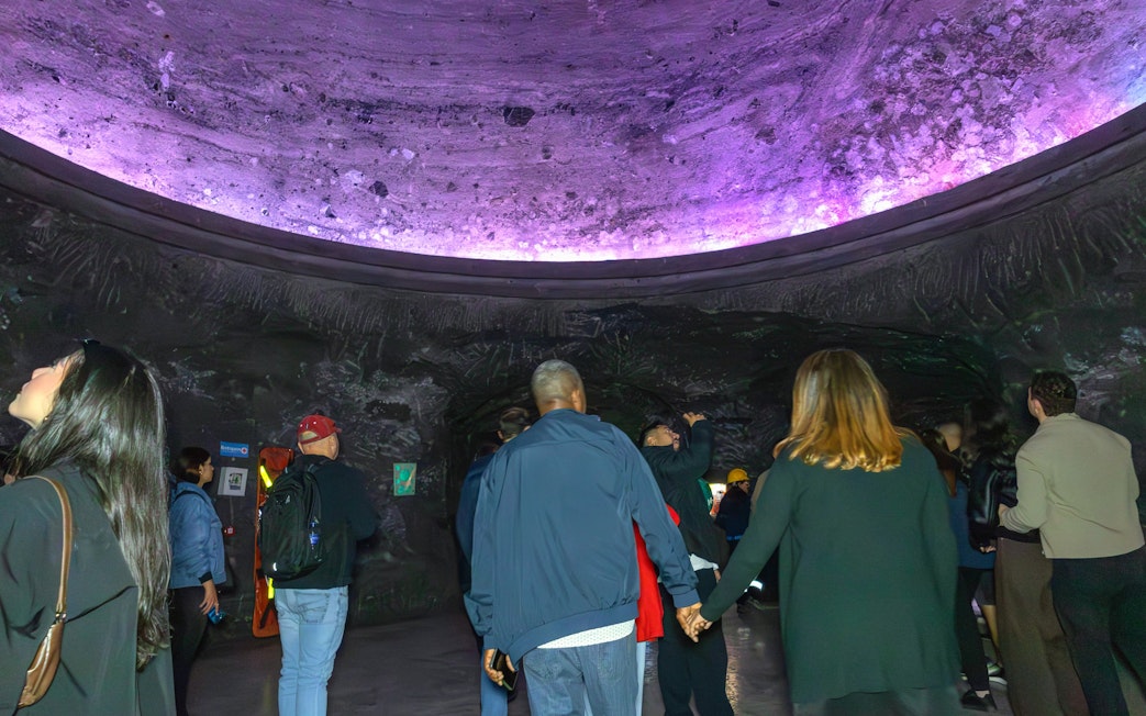 Visitors exploring Zipaquira Salt Cathedral's illuminated cavern in Colombia.