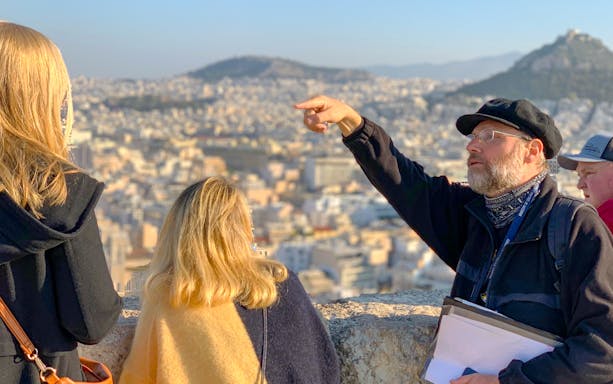 Tour guide pointing out landmarks on Acropolis tour in Athens.