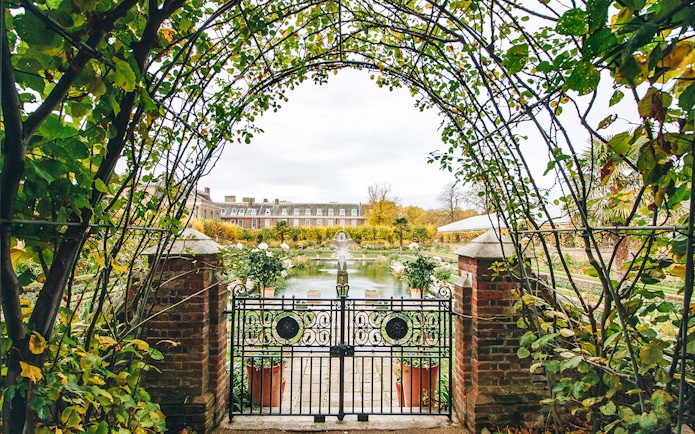 Kensington Palace gardens view through ornate gate, London.