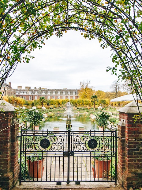 Kensington Palace gardens view through ornate gate, London.