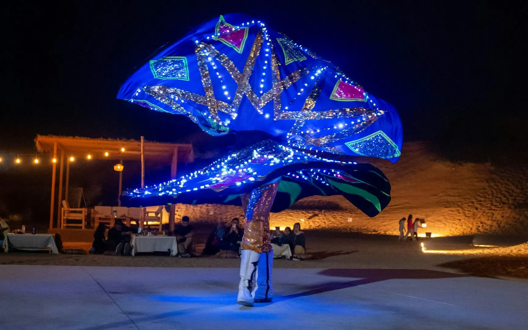 Dancer performing illuminated Tanoura show during Dubai desert safari.