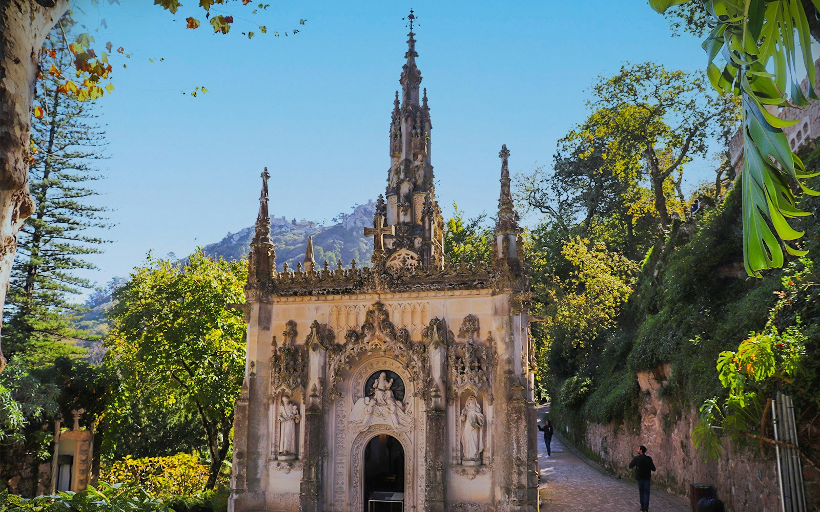 Quinta da Regaleira's ornate chapel surrounded by lush greenery in Sintra, part of Lisbon full-day tour.