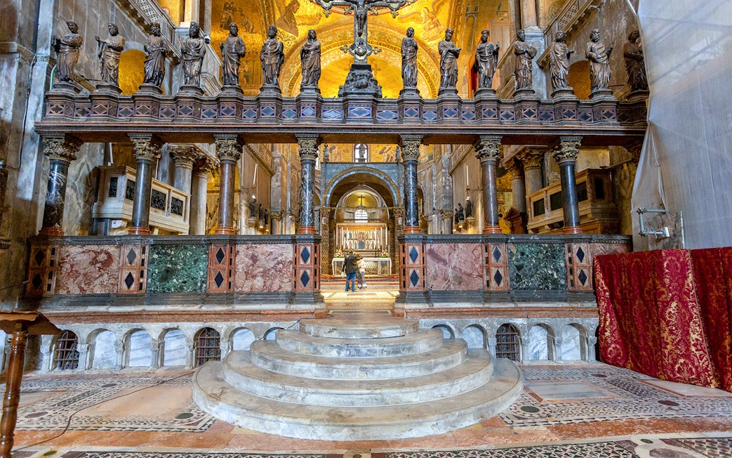 Interior view of St. Mark's Basilica altar with ornate columns and statues, Venice, Italy.