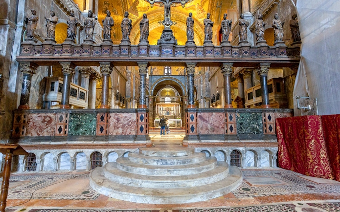 Interior view of St. Mark's Basilica altar with ornate columns and statues, Venice, Italy.