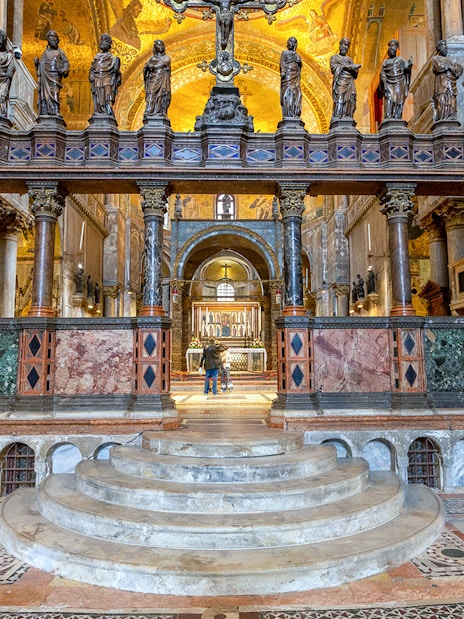 Interior view of St. Mark's Basilica altar with ornate columns and statues, Venice, Italy.
