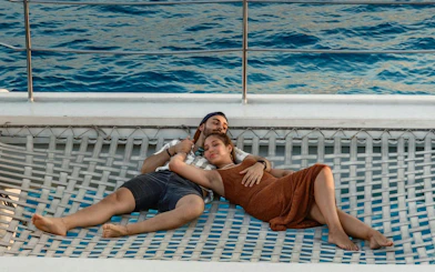 Couple relaxing on a boat net at sunset in Mallorca.