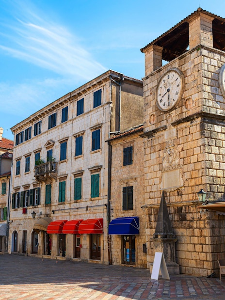 Clock Tower in Arms Square, Kotor Old Town, with surrounding historic buildings.
