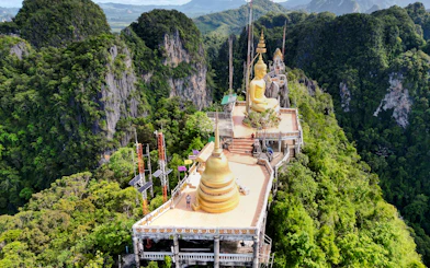Aerial view of Tiger Cave Temple with golden Buddha statue in Krabi, Thailand.