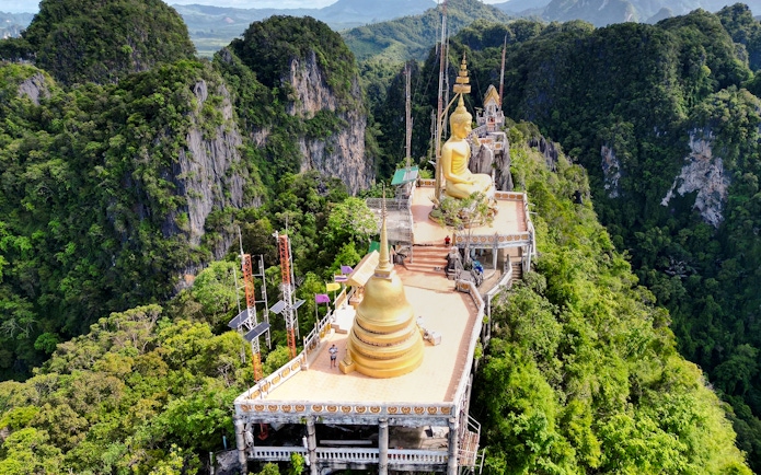 Aerial view of Tiger Cave Temple with golden Buddha statue in Krabi, Thailand.