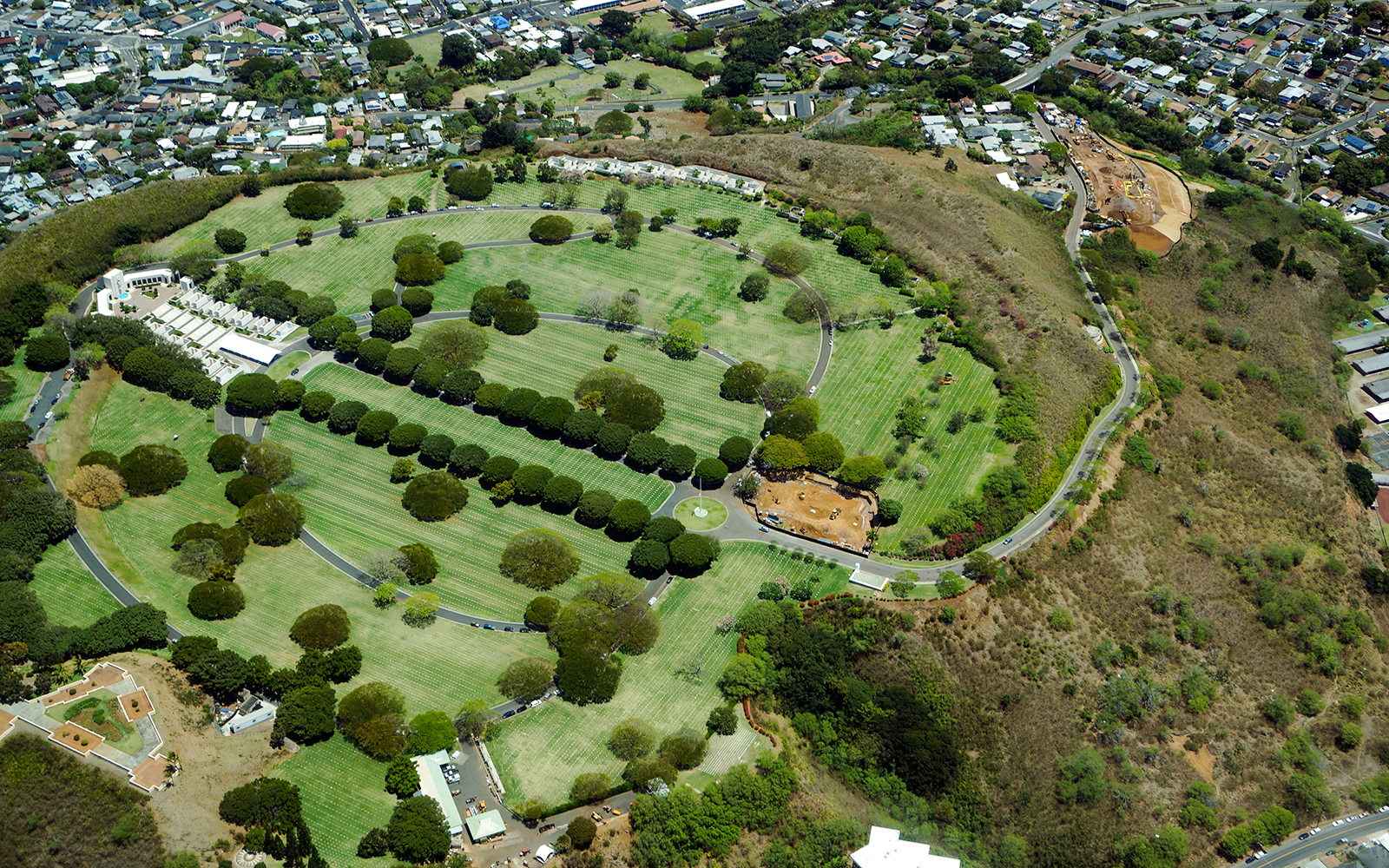 Aerial view of Punchbowl Cemetery, Honolulu, showing circular layout and surrounding landscape.