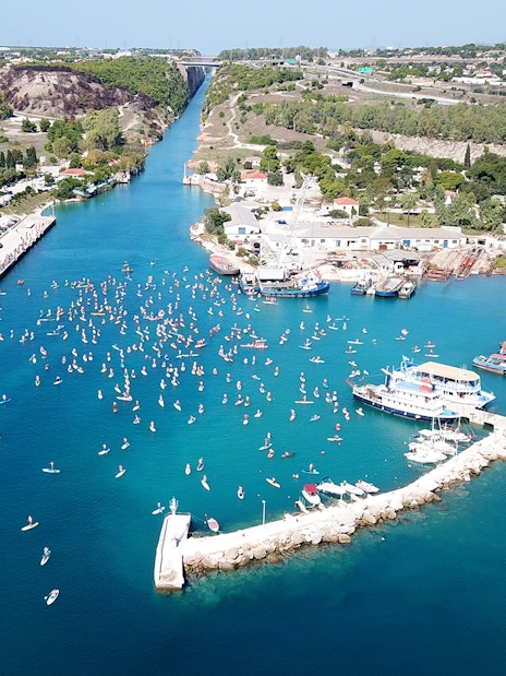 Aerial view of Corinth Canal with boats and paddleboarders, part of Nafplio-Mycenae-Epidaurus Day Tour.