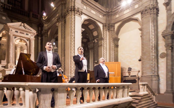 Three tenors performing in a historic Florence venue during a Tuscan dinner concert.