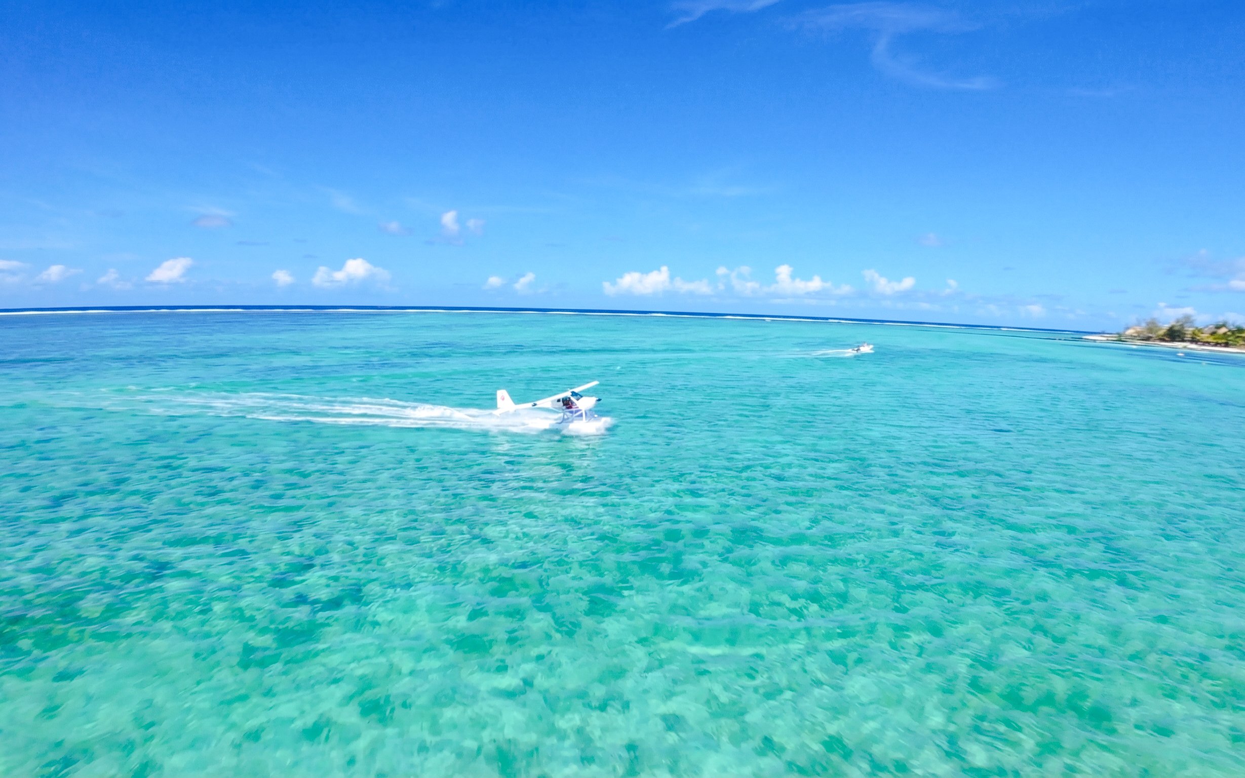 Seaplane flying over turquoise waters on the Short Amber Route Scenic Tour, Mauritius.