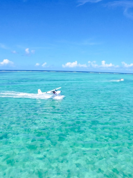 Seaplane flying over turquoise waters on the Short Amber Route Scenic Tour, Mauritius.