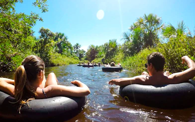 Tubing on a river in Cardosa, Barreirinhas with lush greenery, part of Sao Paulo tour.