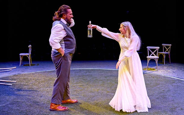Man and woman performing on stage with a bottle, part of "Till The Stars Come Down" show.