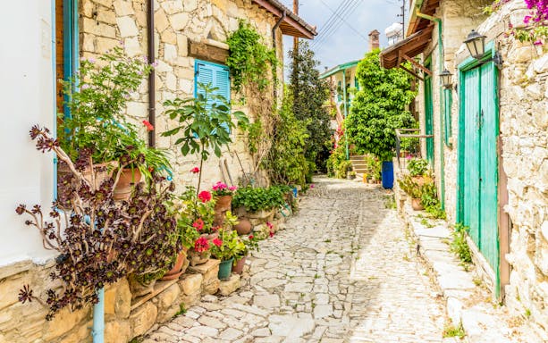 Traditional stone street with colorful flowers in Lania village, Cyprus.