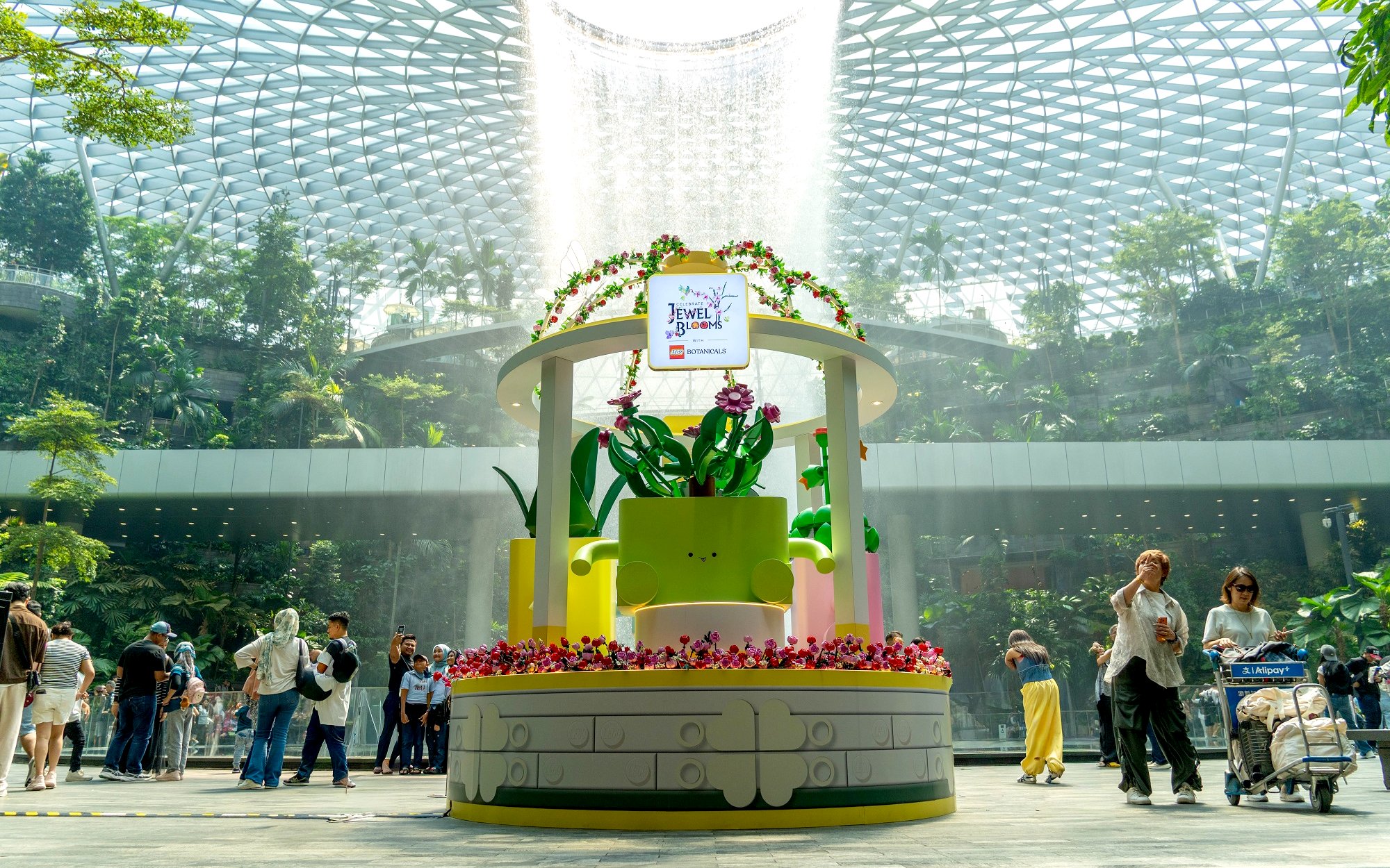 Jewel Changi Airport Canopy Park with floral display and visitors exploring.