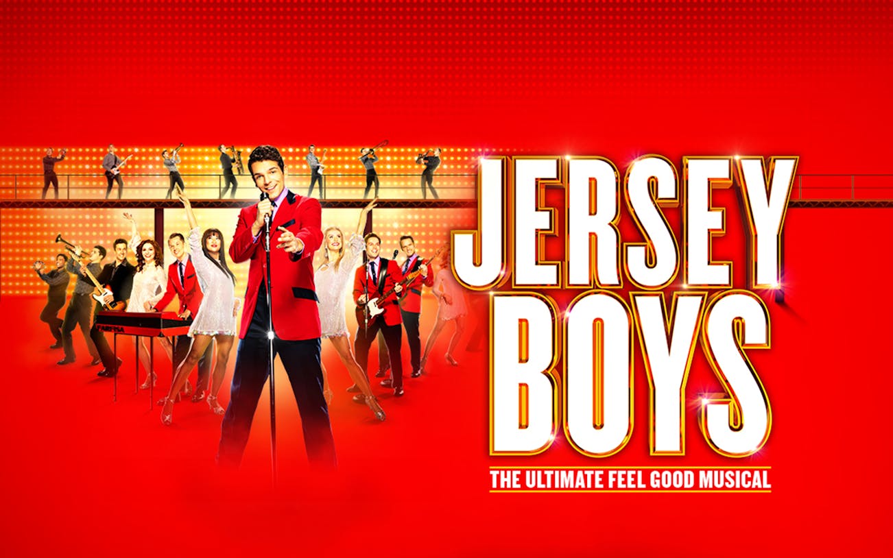 Jersey Boys musical cast performing on stage with bright lights and instruments.