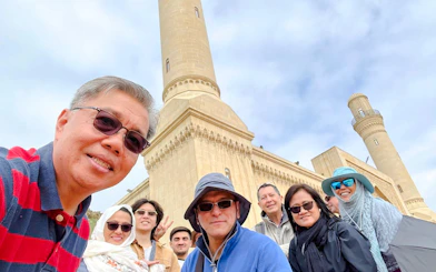 Group of tourists at Gobustan National Park with mud volcanoes in the background.