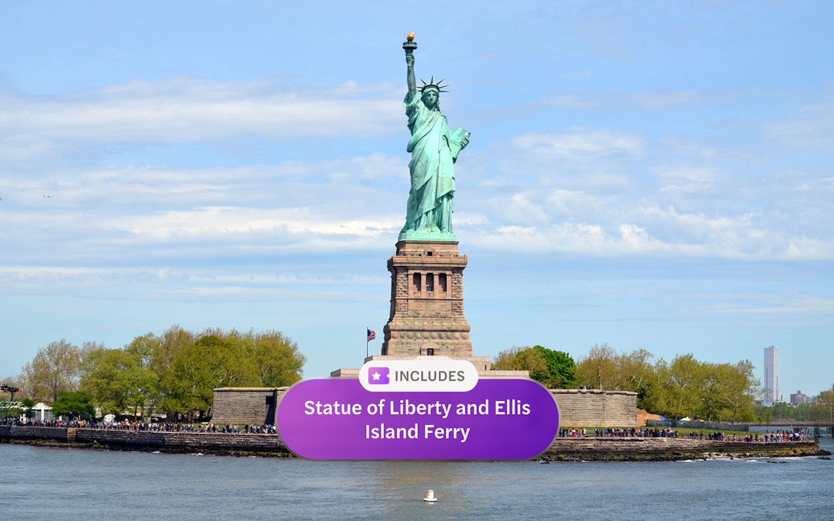 Statue of Liberty with Ellis Island ferry in New York Harbor.