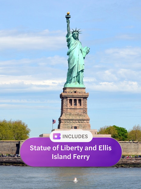 Statue of Liberty with Ellis Island ferry in New York Harbor.