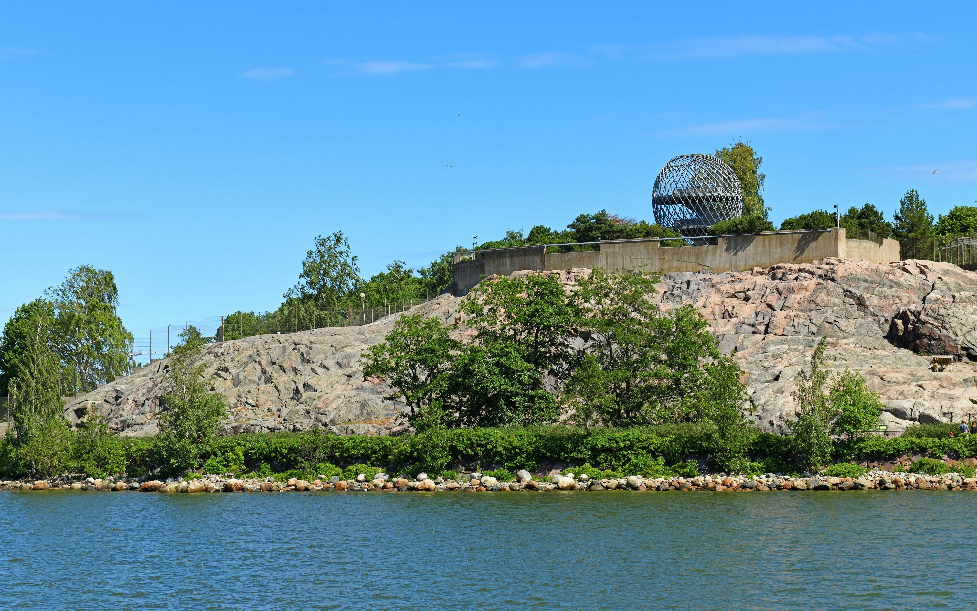 Helsinki Zoo view from the sea with rocky shoreline and greenery, Finland.