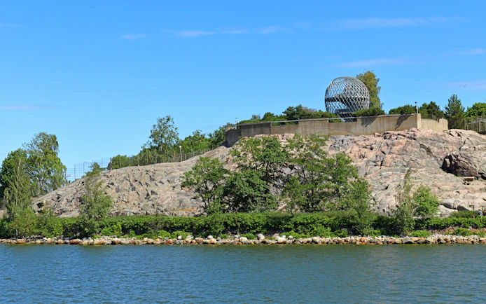 Helsinki Zoo view from the sea with rocky shoreline and greenery, Finland.