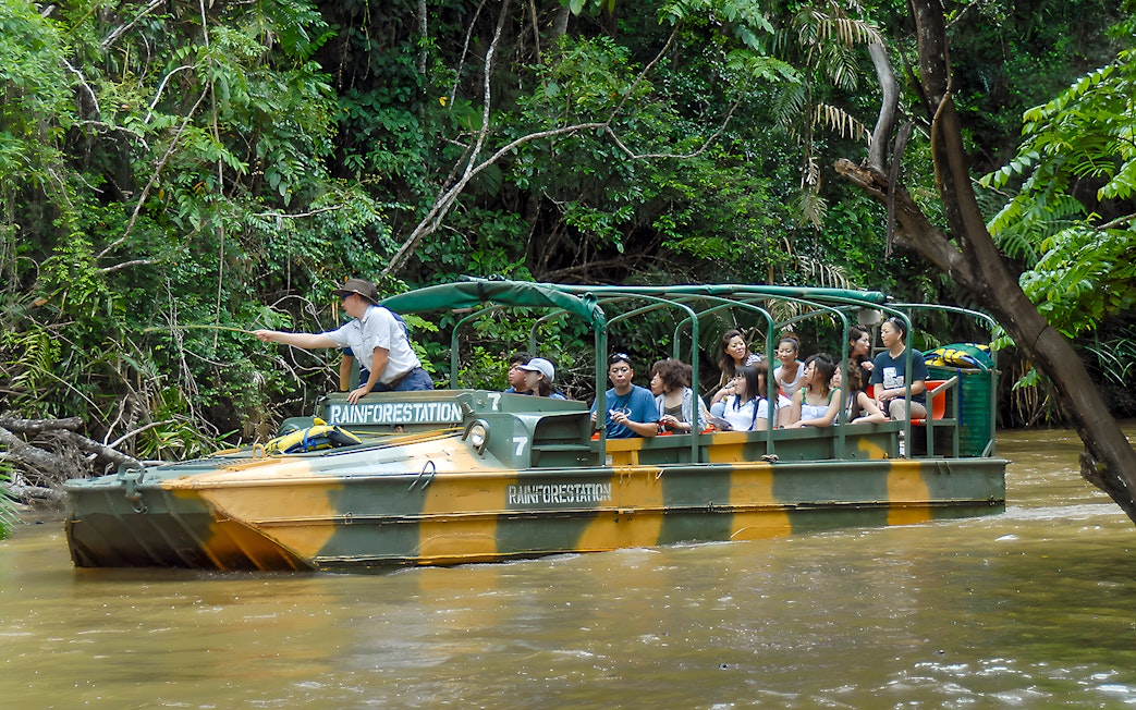 Tourists on an Army Duck boat exploring Kuranda waterways, Queensland rainforest.