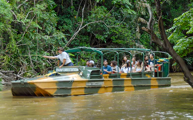 Tourists on an Army Duck boat exploring Kuranda waterways, Queensland rainforest.