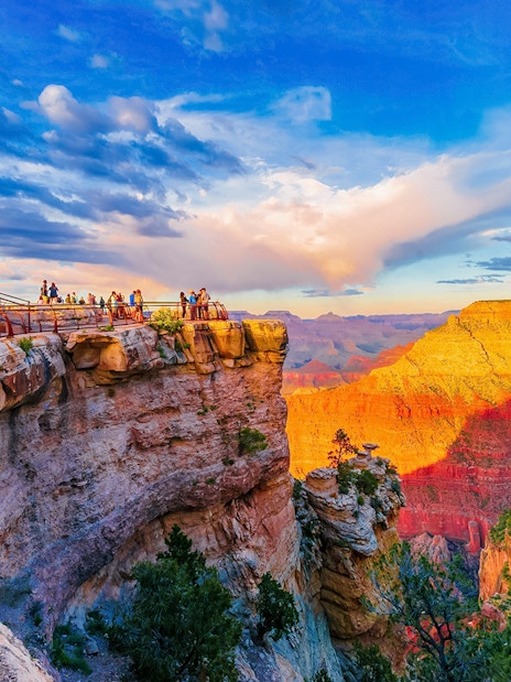 Visitors on the South Rim viewing platform at sunset, Grand Canyon National Park, Arizona, USA.