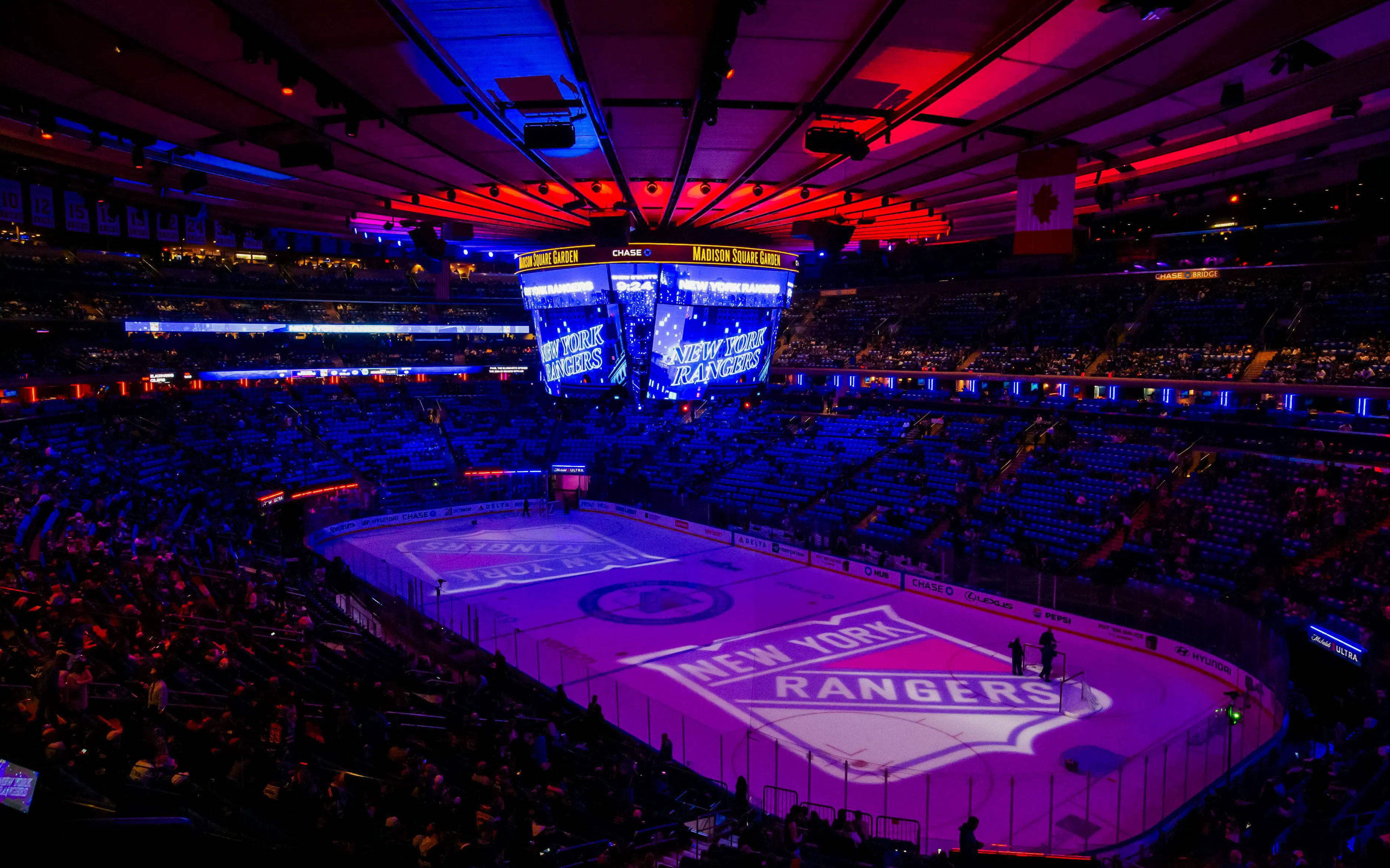 Madison Square Garden ice rink with New York Rangers logo illuminated.
