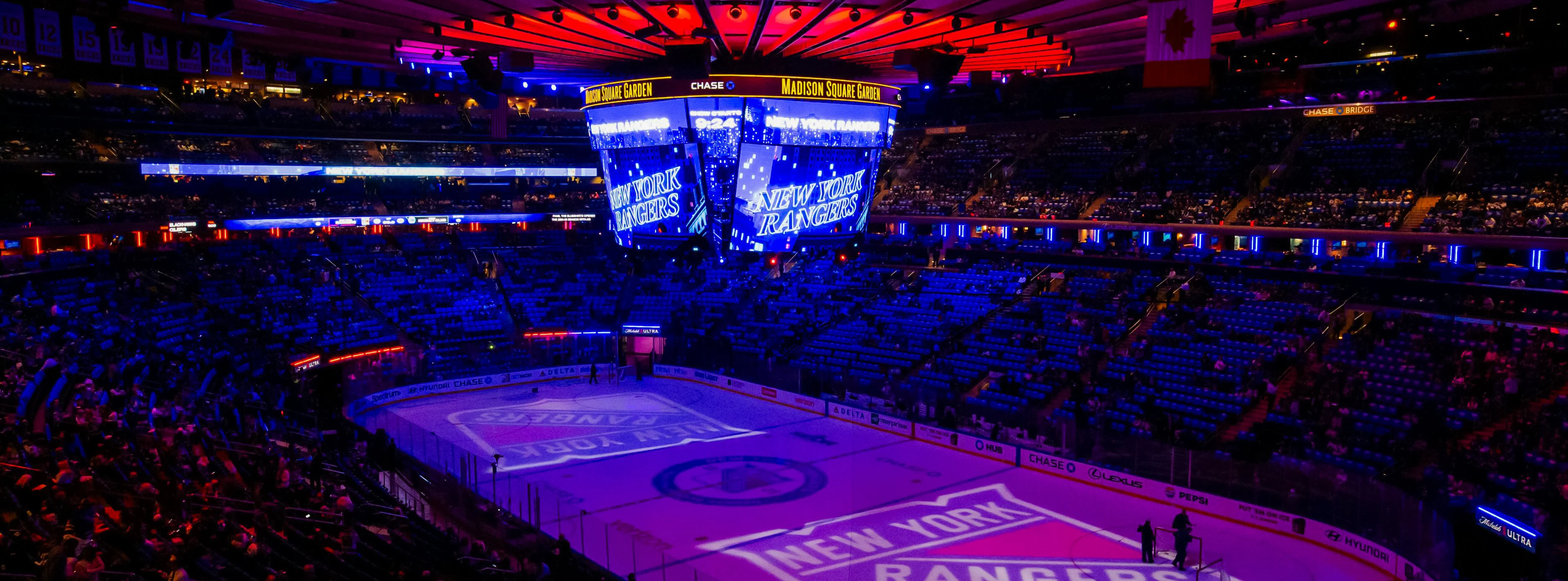 Madison Square Garden ice rink with New York Rangers logo illuminated.