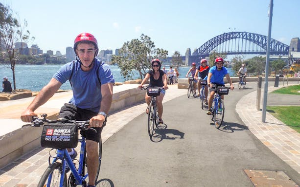 Cyclists on Bonza Bike Tours ride near Sydney Harbour Bridge.