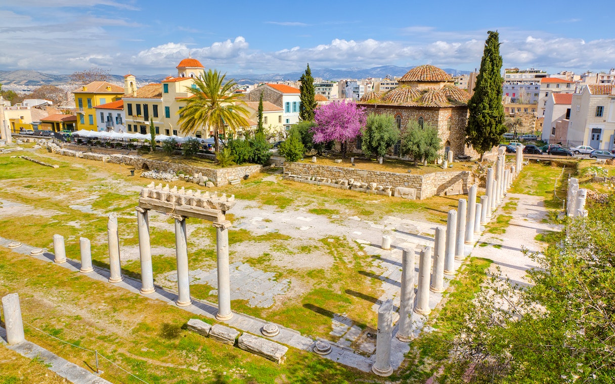 Aerial view of Ancient Agora ruins with columns and surrounding buildings in Athens.