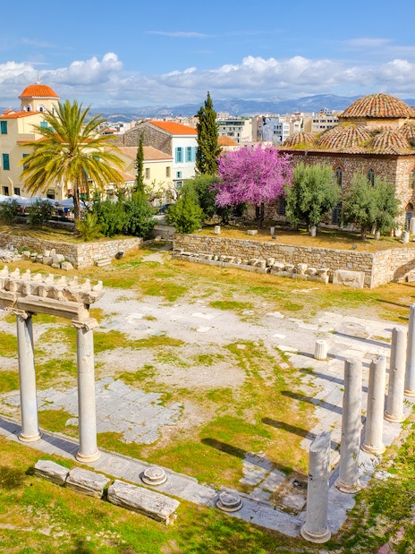 Aerial view of Ancient Agora ruins with columns and surrounding buildings in Athens.