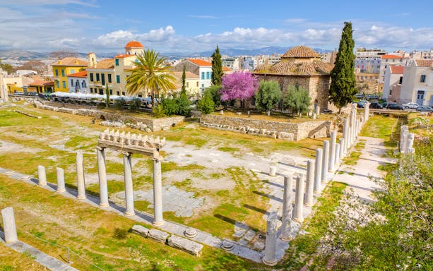 Aerial view of Ancient Agora ruins with columns and surrounding buildings in Athens.