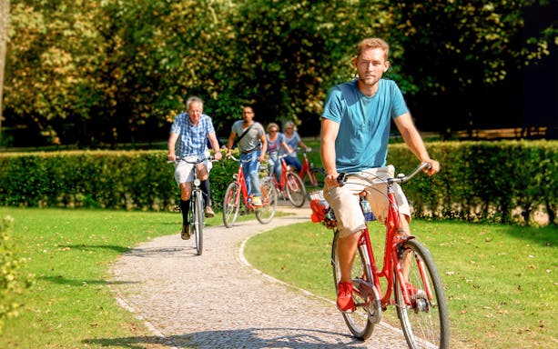 Cyclists on a guided tour ride along a park path in Germany.