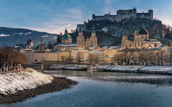 Fortress Hohensalzburg overlooking Salzburg cityscape in winter.