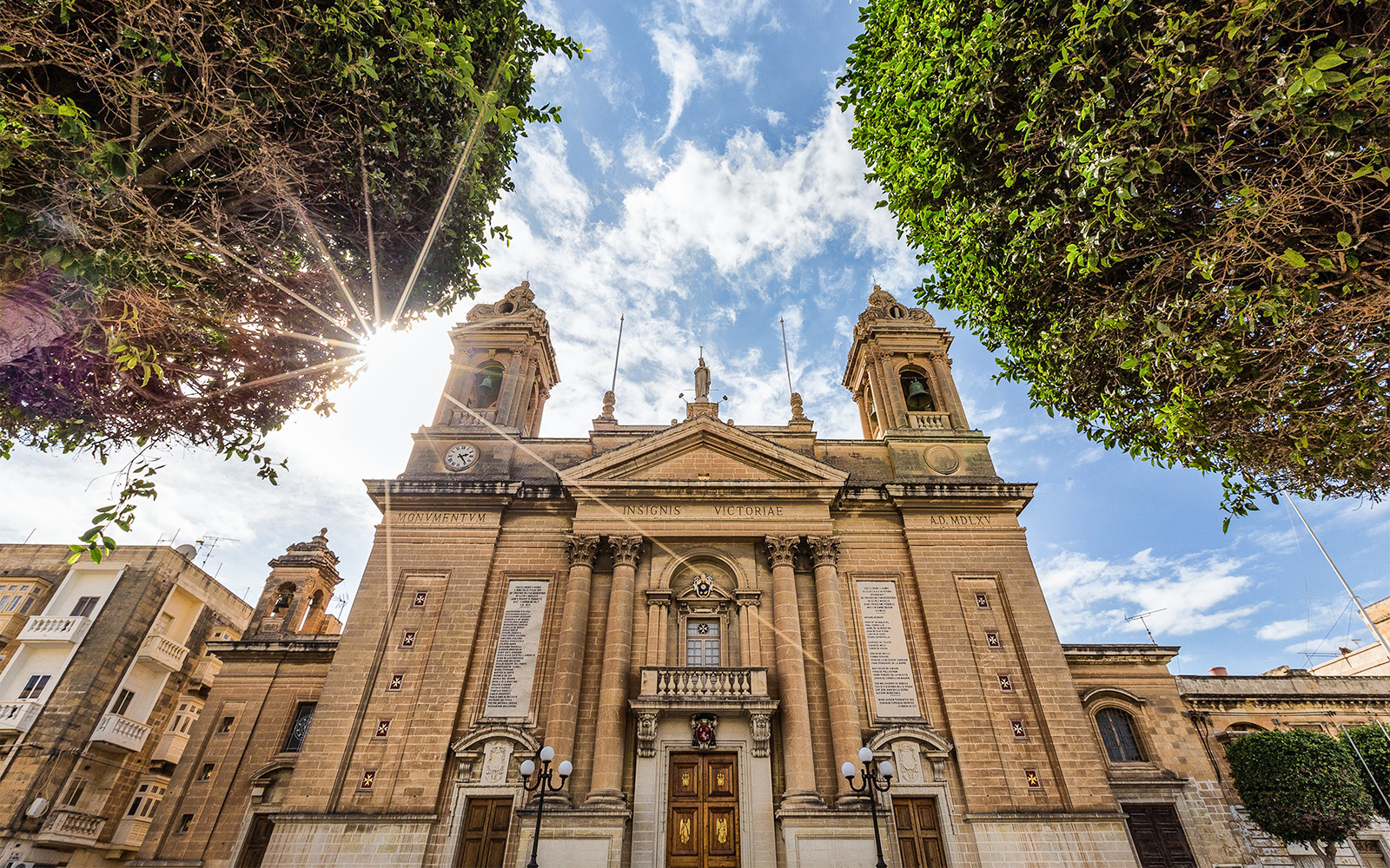 Historic building facade in one of the Three Fortified Cities, Malta, under a sunny sky.