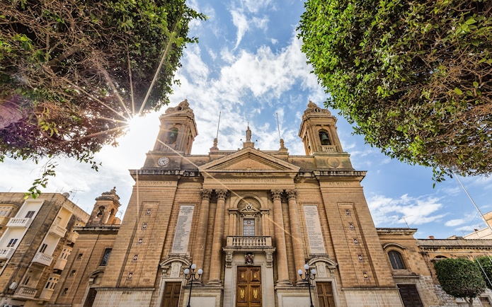 Historic building facade in one of the Three Fortified Cities, Malta, under a sunny sky.